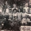На черно - белой фотографии воспитатели детского сада № 2, колхоза имени Кирова, на улице среди цветущих цветов