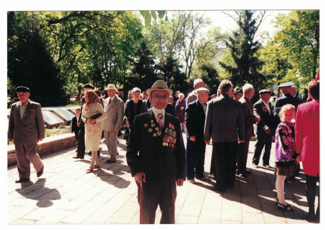 Колонна ветеранов ВОВ идут для возложения цветов к Памятникам в парке, в первом ряду Лях В.В. и Кузьменков несут корзину цветов, 9 мая, 1995 год.